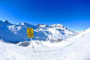 placa de sinal em altas montanhas sob neve no inverno foto