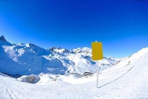 placa de sinal em altas montanhas sob neve no inverno foto