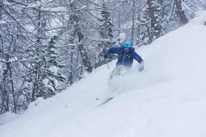 esquiador freeride esquiando na neve em pó profundo foto