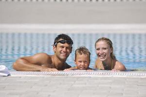 feliz jovem família se divertir na piscina foto