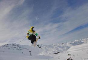 jovem feliz se divertir no inverno no pico da montanha foto