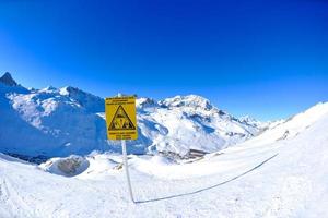 placa de sinal em altas montanhas sob neve no inverno foto