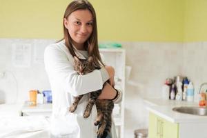 clínica veterinária. retrato de médica no hospital de animais segurando gato doente bonito foto