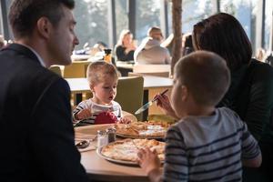 pais jovens aproveitando a hora do almoço com seus filhos foto