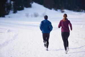 casal correndo lá fora na neve foto