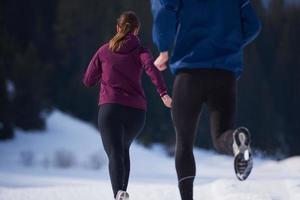 casal correndo lá fora na neve foto