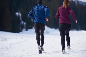 casal correndo lá fora na neve foto