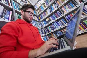 os alunos usam um notebook, laptop e uma biblioteca escolar foto