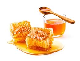 favo de mel com pote e colher de mel isolado no fundo branco foto