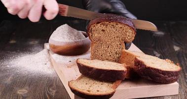 um pedaço retangular de pão de centeio escuro é cortado em pedaços foto