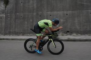 atleta de triatlo andando de bicicleta no treinamento matinal foto