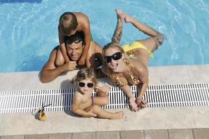 feliz jovem família se divertir na piscina foto