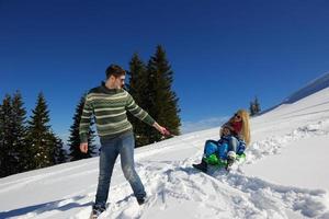 família se divertindo na neve fresca nas férias de inverno foto