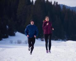 casal correndo lá fora na neve foto