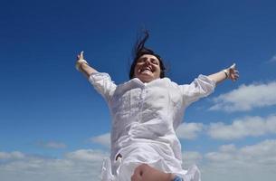 mulher jovem feliz com braços abertos para o céu foto