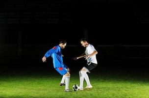 jogadores de futebol em ação para a bola foto