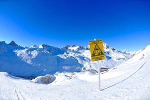 placa de sinal em altas montanhas sob neve no inverno foto