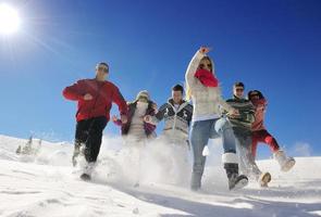 amigos se divertem no inverno na neve fresca foto