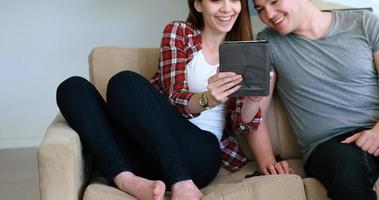 jovem casal usando tablet digital em casa foto