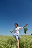 jovem mulher feliz em campo verde foto