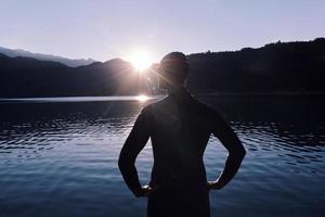 atleta de triatlo iniciando treinamento de natação no lago foto