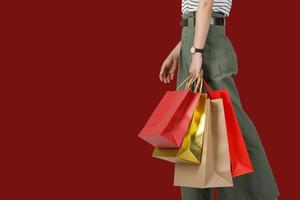 mulher de compras segurando sacolas de compras em fundo vermelho, copie o espaço para o seu texto, conceito de estilo de vida de marketing digital de comércio eletrônico foto
