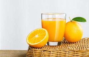 copo de suco de laranja fresco em uma cesta, suco de laranja de frutas frescas em vidro com grupo de laranja no fundo branco, foco seletivo no vidro, isolar o fundo branco foto