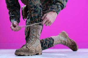 soldado amarrando os cadarços em suas botas foto