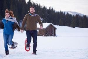 casal se divertindo e andando com sapatos de neve foto