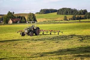 o trator e o feno preparam a colheita do feno para o cultivo. conceito de agricultura e agronomia. foco seletivo foto