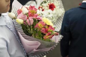 crianças no dia do conhecimento. alunos da primeira série vão para a escola. crianças com flores para professor. foto