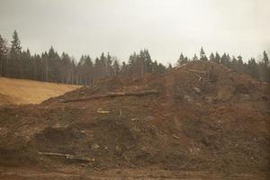 montanha de areia na linha. terra escavada. início da construção do entroncamento rodoviário. foto
