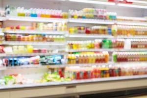 prateleiras de geladeira de supermercado com produto de refrigerante de suco de fruta abstrato desfocar o fundo foto