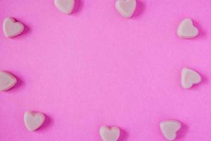 forma de corações de doces de dia dos namorados no fundo rosa foto