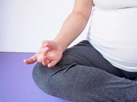 mulher grávida fazendo yoga em casa foto