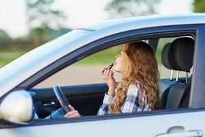 mulher aplicando batom em um carro enquanto dirigia foto