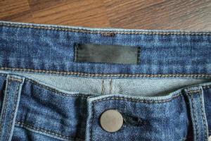 jeans azul com etiqueta de etiqueta de roupas em branco foto