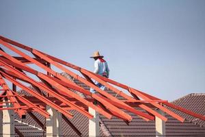 trabalhadores de solda instalando estrutura de armação de aço do telhado da casa no canteiro de obras foto