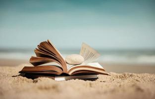 lendo livro ao ar livre no conceito de verão. livro aberto na areia da praia em frente ao mar em dia ensolarado. estilo de vida nas férias foto