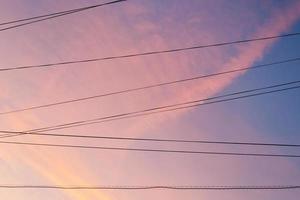 condutores elétricos e nuvens do pôr do sol rosa foto