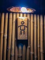 sinal de genderman na frente do vintage de bambu clássico e banheiro retrô interior com pouca luz. foto