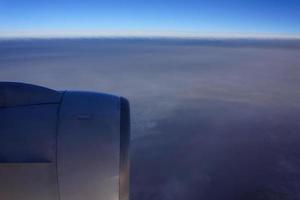 vista do céu da janela do avião a jato com asa da máquina pela manhã. foto