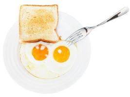 café da manhã com dois ovos fritos em chapa branca foto