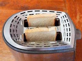 duas fatias de pão fresco na torradeira de metal foto