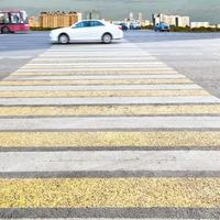 zebra de cruzamento amarela e branca na rua urbana foto