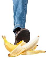 perna esquerda em jeans e sapato pisando na banana foto