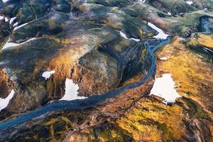 montanha vulcânica surreal cênica com rio através do campo de lava localizado remoto nas terras altas da islândia foto