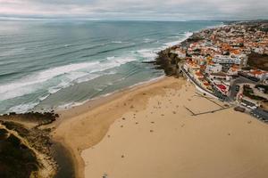 vista aérea de drone da cidade costeira de portugal com casas no mercado imobiliário em sintra, lisboa, europa, propriedades no topo da falésia e casas na costa com vista para o mar na praia das macas foto