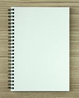 caderno espiral em branco sobre fundo de madeira foto