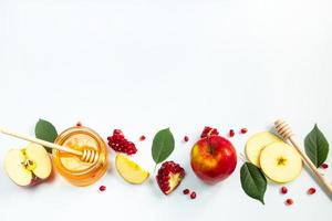conceito de feriado judaico tradicional de rosh hashaná. ano Novo. romãs, mel e maçãs em fundo branco. lugar para o seu texto. foto